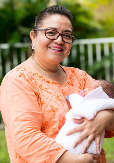 Woman Holding Swaddled Baby Smiling at Camera