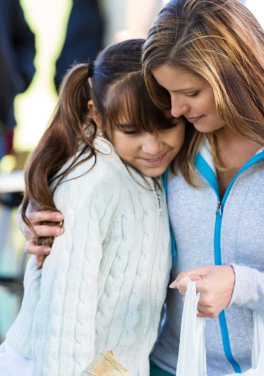 Woman Side Hugging Girl in Pigtails