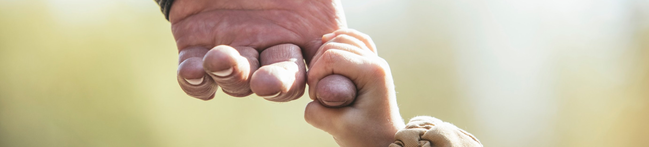 baby-holding-a-mans-finger-close-up.jpg
