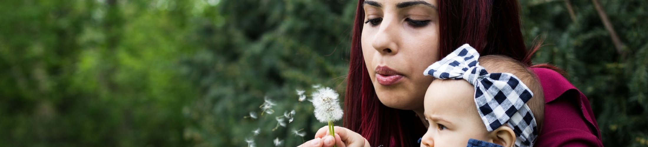 lady-holding-baby-blowing-dandilion.jpg